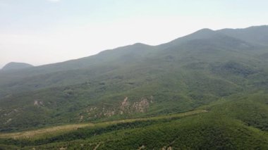 Gökyüzünden yeşillik manzaralı dağlar. Bir kuadrokopterden video