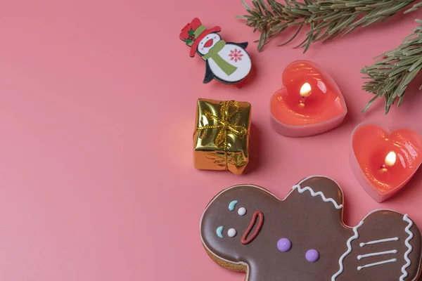 Kerstspeelgoed kaarsen en koekjes op een roze achtergrond in een wazig — Stockfoto