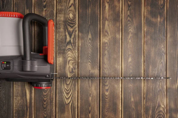 Electric chain saw on wood on a wooden background. Top view — Stock Photo, Image