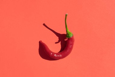Kırmızı arka planda koyu gölgeli kırmızı biber