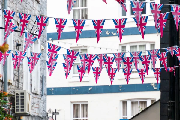 Brittiska Union Jack flagga triangulära hängande som förberedelse för en gatufest. Festliga dekorationer av Union Jack bunting. Royaltyfria Stockfoton