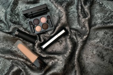 Profesyonel dekoratif makyaj malzemeleri, makyaj malzemeleri ve parlak gümüş arka planda metin için fotokopi alanı olan aksesuarlar. Güzellik, moda, parti ve alışveriş konsepti. Düz yatış, üst görünüm