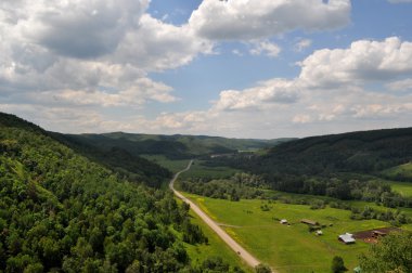 Güneşli bir yol ve Zümrüt tepeleri