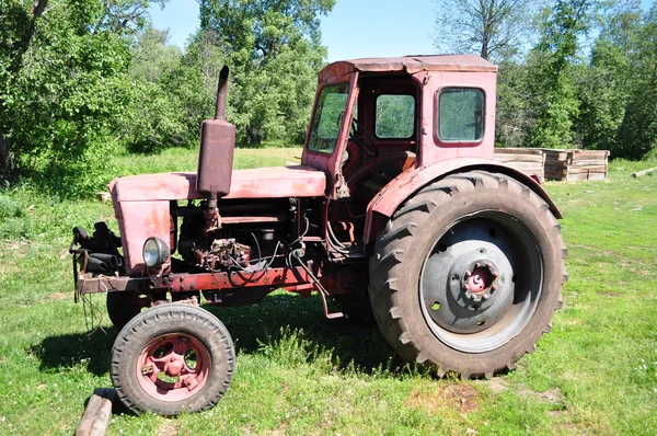 Old red tractor in the yard — Stock Photo, Image