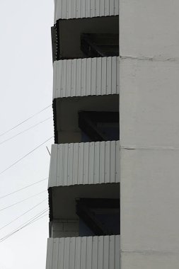 Köşe balkonları olan çok katlı bir binanın parçası.