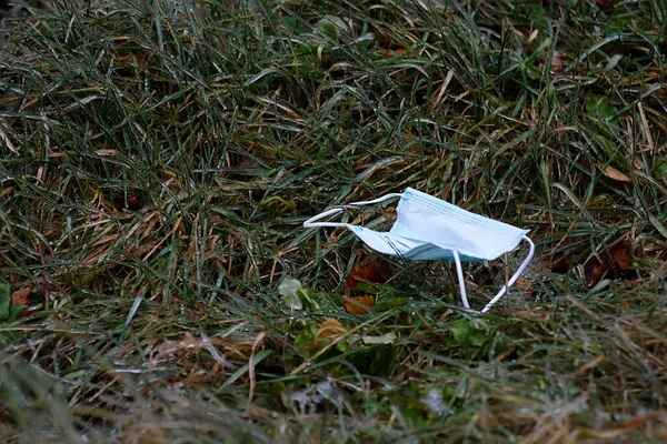 Maschera Protettiva Usata Sdraiata Sull Erba Congelata — Foto Stock