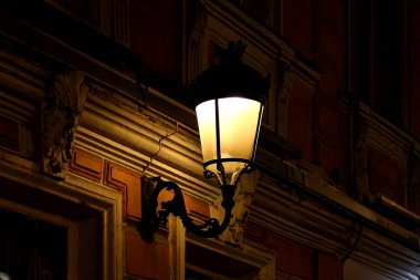 Eski bir binanın duvarında eski bir fener var.