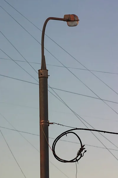 the light pole and wires against the sky