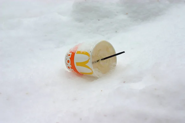 一个装有稻草的纸杯被扔进了雪中 — 图库照片