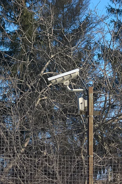 security camera on a post near a chain link fence