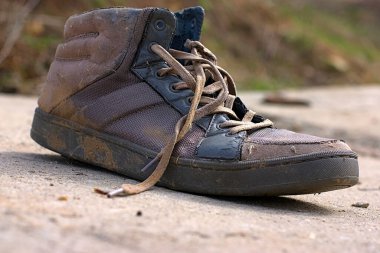 Yolun beton levhasında eski bir ayakkabı.