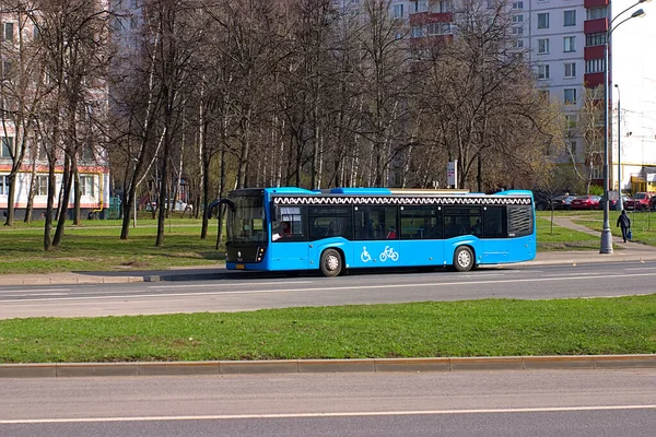 blue city bus departs from the bus stop