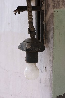 Evin duvarında eski bir kartuş içinde elektrik lambası.