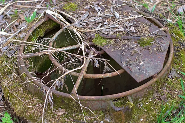 森林公园草坪上的旧下水道井眼 — 图库照片