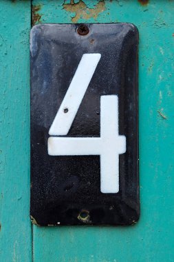 Evin yanındaki çitin üzerinde 4 numaralı metal plaka.