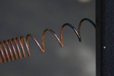 Yakın planda paslı bir metal yay.