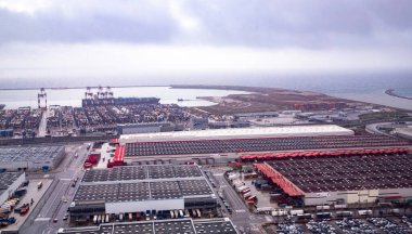 Vinçleri, nakliye konteynerleri ve modern deniz ticaret ve lojistiği temsil eden kargo gemisiyle sanayi limanının yüksek açılı görüntüsü. Barselona İspanya 27.03.2024