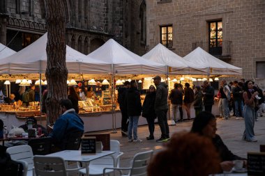 Christmas tree with cupcake-shaped decorations, snowmen, and gold and red baubles against a store backdrop. Christmas store in Barcelona Spain 30.11.2025.