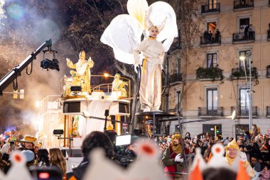 Akşam Barselona sokaklarında üç kralın geçit töreni. Barcelona İspanya Geçit Töreni 'nde Parlak Karnaval kostümlü oyuncular 05.01.2026