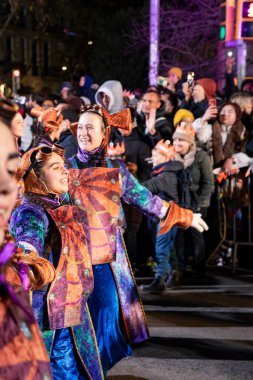 Akşam Barselona sokaklarında üç kralın geçit töreni. Barcelona İspanya Geçit Töreni 'nde Parlak Karnaval kostümlü oyuncular 05.01.2026