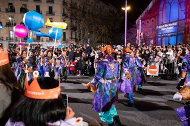 Akşam Barselona sokaklarında üç kralın geçit töreni. Barcelona İspanya Geçit Töreni 'nde Parlak Karnaval kostümlü oyuncular 05.01.2026