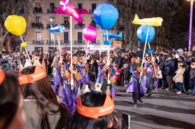Akşam Barselona sokaklarında üç kralın geçit töreni. Barcelona İspanya Geçit Töreni 'nde Parlak Karnaval kostümlü oyuncular 05.01.2026