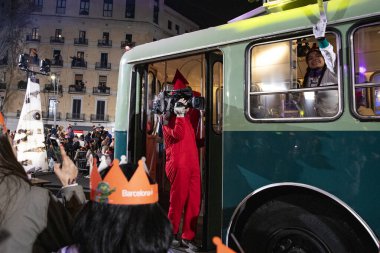 Akşam Barselona sokaklarında üç kralın geçit töreni. Barcelona İspanya Geçit Töreni 'nde Parlak Karnaval kostümlü oyuncular 05.01.2026