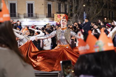 Akşam Barselona sokaklarında üç kralın geçit töreni. Barcelona İspanya Geçit Töreni 'nde Parlak Karnaval kostümlü oyuncular 05.01.2026