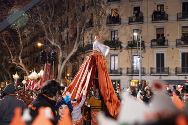 Akşam Barselona sokaklarında üç kralın geçit töreni. Barcelona İspanya Geçit Töreni 'nde Parlak Karnaval kostümlü oyuncular 05.01.2026