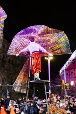 Akşam Barselona sokaklarında üç kralın geçit töreni. Barcelona İspanya Geçit Töreni 'nde Parlak Karnaval kostümlü oyuncular 05.01.2026