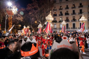 Akşam Barselona sokaklarında üç kralın geçit töreni. Barcelona İspanya Geçit Töreni 'nde Parlak Karnaval kostümlü oyuncular 05.01.2026