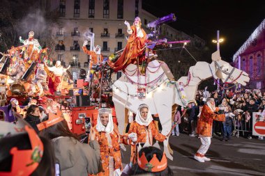 Akşam Barselona sokaklarında üç kralın geçit töreni. Barcelona İspanya Geçit Töreni 'nde Parlak Karnaval kostümlü oyuncular 05.01.2026