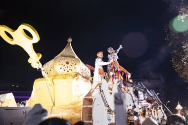 Akşam Barselona sokaklarında üç kralın geçit töreni. Barcelona İspanya Geçit Töreni 'nde Parlak Karnaval kostümlü oyuncular 05.01.2026