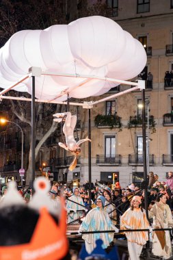 Akşam Barselona sokaklarında üç kralın geçit töreni. Barcelona İspanya Geçit Töreni 'nde Parlak Karnaval kostümlü oyuncular 05.01.2026