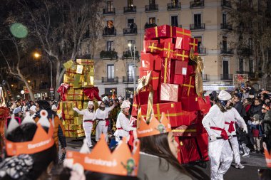 Akşam Barselona sokaklarında üç kralın geçit töreni. Barcelona İspanya Geçit Töreni 'nde Parlak Karnaval kostümlü oyuncular 05.01.2026