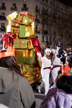 Akşam Barselona sokaklarında üç kralın geçit töreni. Barcelona İspanya Geçit Töreni 'nde Parlak Karnaval kostümlü oyuncular 05.01.2026