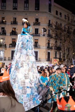 Akşam Barselona sokaklarında üç kralın geçit töreni. Barcelona İspanya Geçit Töreni 'nde Parlak Karnaval kostümlü oyuncular 05.01.2026