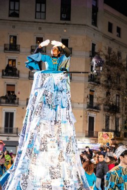 Akşam Barselona sokaklarında üç kralın geçit töreni. Barcelona İspanya Geçit Töreni 'nde Parlak Karnaval kostümlü oyuncular 05.01.2026