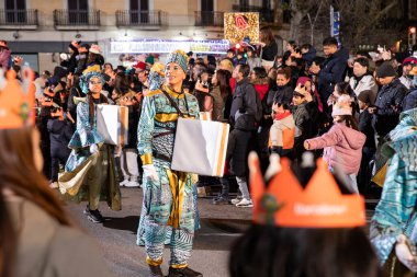 Akşam Barselona sokaklarında üç kralın geçit töreni. Barcelona İspanya Geçit Töreni 'nde Parlak Karnaval kostümlü oyuncular 05.01.2026