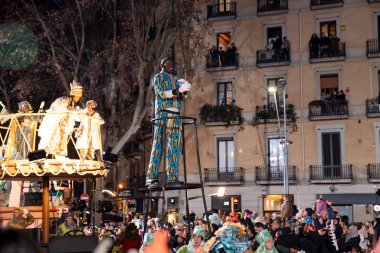 Akşam Barselona sokaklarında üç kralın geçit töreni. Barcelona İspanya Geçit Töreni 'nde Parlak Karnaval kostümlü oyuncular 05.01.2026