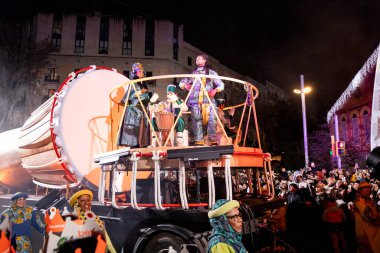 Akşam Barselona sokaklarında üç kralın geçit töreni. Barcelona İspanya Geçit Töreni 'nde Parlak Karnaval kostümlü oyuncular 05.01.2026