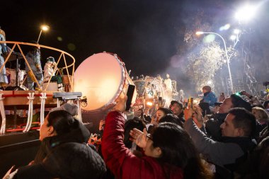 Akşam Barselona sokaklarında üç kralın geçit töreni. Barcelona İspanya Geçit Töreni 'nde Parlak Karnaval kostümlü oyuncular 05.01.2026