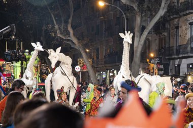 Akşam Barselona sokaklarında üç kralın geçit töreni. Barcelona İspanya Geçit Töreni 'nde Parlak Karnaval kostümlü oyuncular 05.01.2026