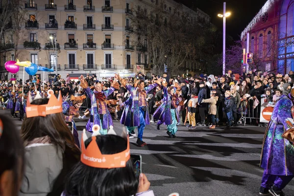 Akşam Barselona sokaklarında üç kralın geçit töreni. Barcelona İspanya Geçit Töreni 'nde Parlak Karnaval kostümlü oyuncular 05.01.2026
