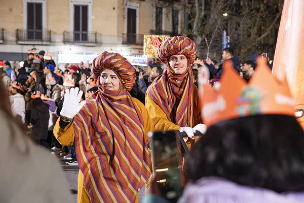 Akşam Barselona sokaklarında üç kralın geçit töreni. Barcelona İspanya Geçit Töreni 'nde Parlak Karnaval kostümlü oyuncular 05.01.2026