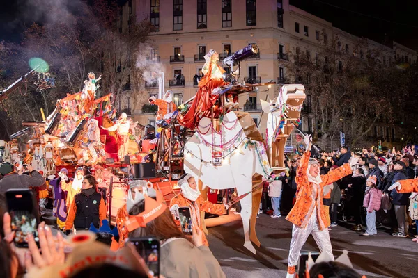 Akşam Barselona sokaklarında üç kralın geçit töreni. Barcelona İspanya Geçit Töreni 'nde Parlak Karnaval kostümlü oyuncular 05.01.2026