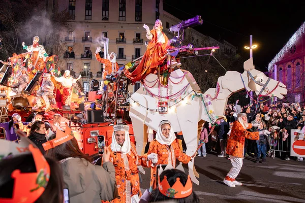 Akşam Barselona sokaklarında üç kralın geçit töreni. Barcelona İspanya Geçit Töreni 'nde Parlak Karnaval kostümlü oyuncular 05.01.2026
