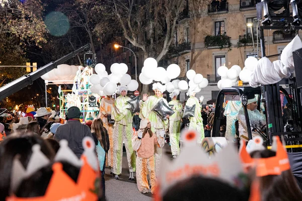 Akşam Barselona sokaklarında üç kralın geçit töreni. Barcelona İspanya Geçit Töreni 'nde Parlak Karnaval kostümlü oyuncular 05.01.2026