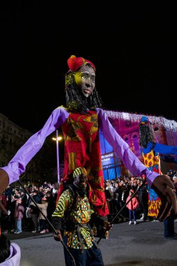Akşam Barselona sokaklarında üç kralın geçit töreni. Barcelona İspanya Geçit Töreni 'nde Parlak Karnaval kostümlü oyuncular 05.01.2026