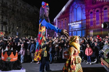 Akşam Barselona sokaklarında üç kralın geçit töreni. Barcelona İspanya Geçit Töreni 'nde Parlak Karnaval kostümlü oyuncular 05.01.2026